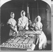 SA0212 - Three Shaker women, Edna Fritts, Elizabeth Martin, and Mary Louisa Wilson, molding maple sugar cakes., Winterthur Shaker Photograph and Post Card Collection 1851 to 1921c